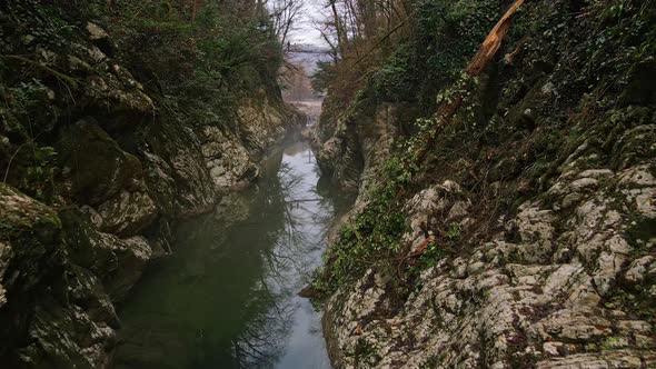 Flying Over a River Through a Narrow Canyon with White Rocks Sochi