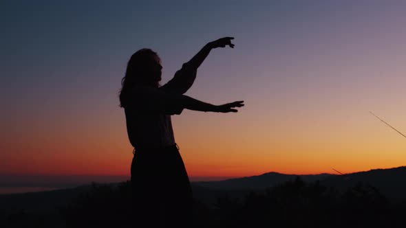 Silhouette of a Dancing Girl at Sunset Light