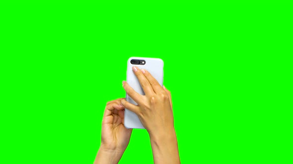 Woman Hands Using White Smartphone. Green Screen Background. Close Up