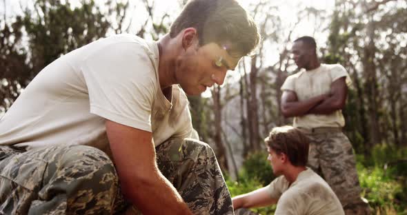 Military soldier tying shoelaces at boot camp 4k