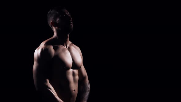 Fit and sporty bodybuilder over black background.