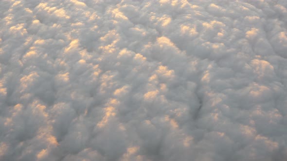 Airplane window view of clouds floating in the sky below the aircraft