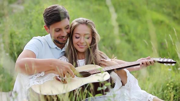 Couple In Love On Nature, Man Teaching Woman Playing In Guitar