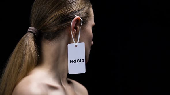 Woman Taking Off Frigid Label From Ear, Protest Against Insecurities in Sex