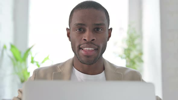 Close Up of African Man with Laptop Showing Thumbs Up