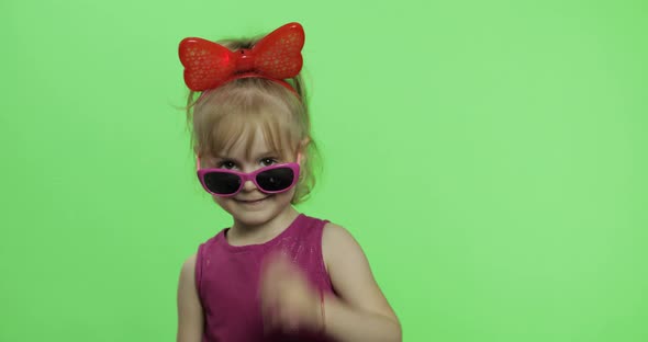 Girl Dancing in Purple Dress, Sunglasses and Red Ribbon on Head. Chroma Key