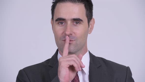 Happy Handsome Businessman with Finger on Lips