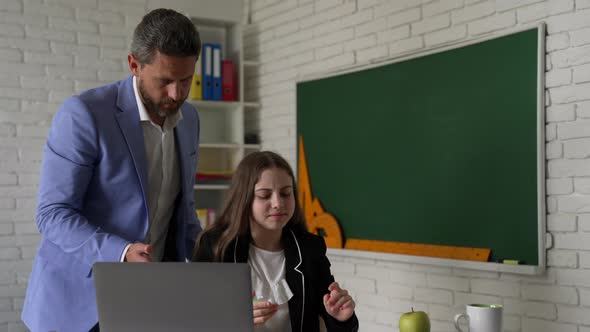 Teacher and Kid Study Online with Laptop in Classroom Education