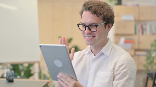 Portrait of Video Call on Tablet By Young Man in Modern Office