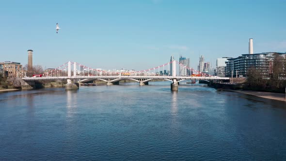 Dolly forward rising reveal shot of London over Chelsea Bridge