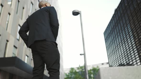 Serious African businessman walking and sitting on the bench