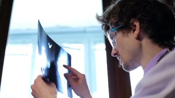 A doctor examines an X-ray of a patient in a clinic.