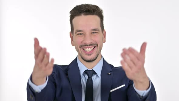 Portrait of Young Businessman Pointing Finger and Inviting, White Background