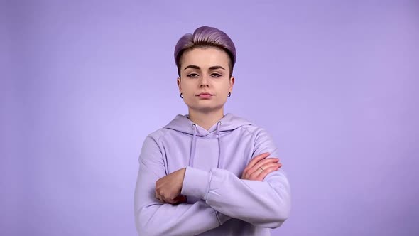 Angry Young Woman Folding Arms Crossed on Purple Background Indoors