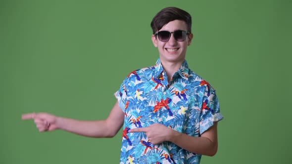 Young Handsome Iranian Teenage Boy Ready for Vacation Against Green Background