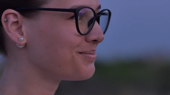 Young smiling woman in glasses on green background