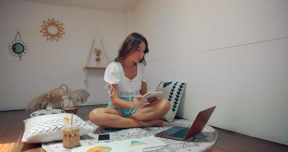 Cute Woman Seats in Lotus Pose and Doing Freelance Work at Home in Cozy Place Upstairs the House