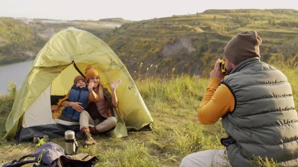 Man Taking Photos of Woman and Boy in Tent