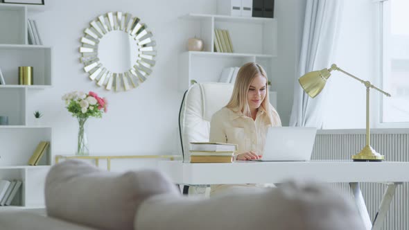 Young attractive woman holding video conference remotely from white room