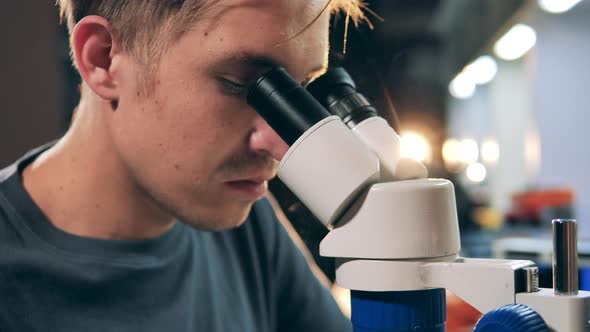 Repairman Soldering Integrated Circuit Through Microscope