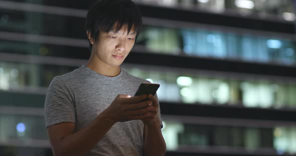 Man use of cellphone in city at night