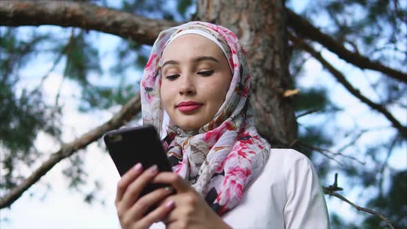 Muslim Girl Using Cellphone in the Park