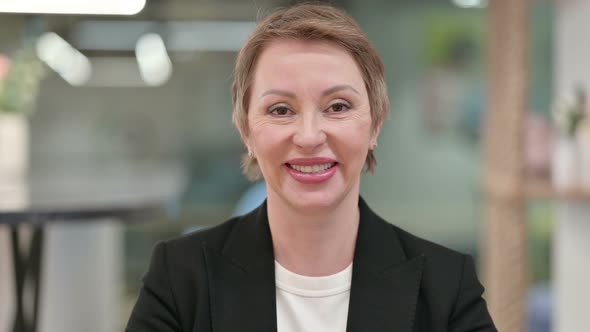 Smiling Old Businesswoman Looking at Camera 