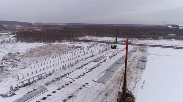 Aerial drone view of a pile bore machines at winter construction site 13