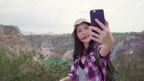 Asian backpacker woman record vlog video on top of mountain using mobile phone make vlog video.