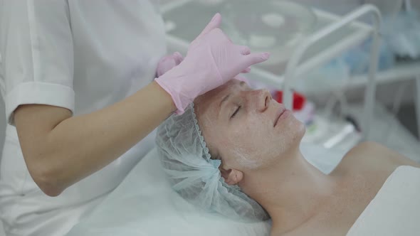 Cosmetologist Gives Facial Massage to Young Woman Without Makeup