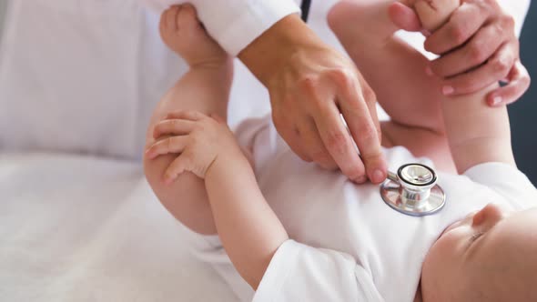 Doctor with Stethoscope Listening To Baby Patient