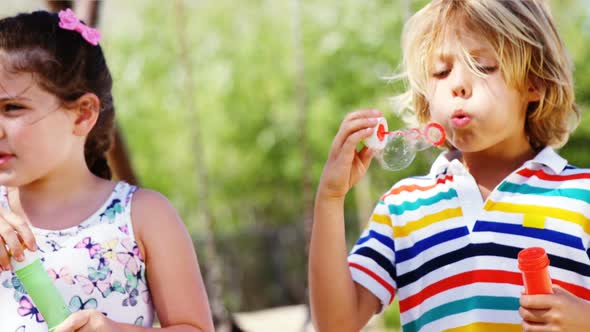 Schoolkids playing with bubble wand in playground