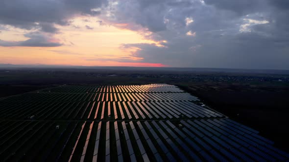 Aerial view of Solar Power Plant at Dusk. Bird's-eye view, Drone flying over a Solar Farm.