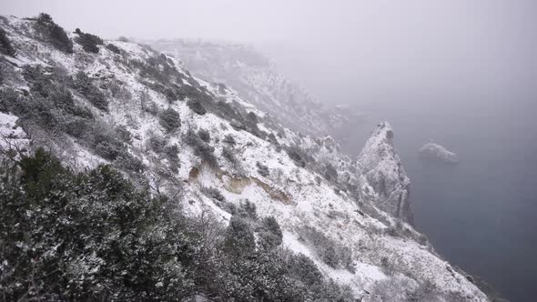 Snow Covered Rocky Cliffs Over Sea