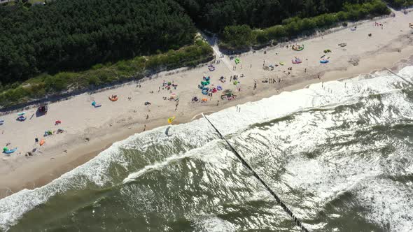 Beach in Chalupy resort in Poland. Aerial video. Baltic Sea. People on towels.