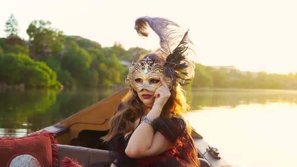 Beautiful Woman in Black Dress with Carnival Mask Riding on Gondola