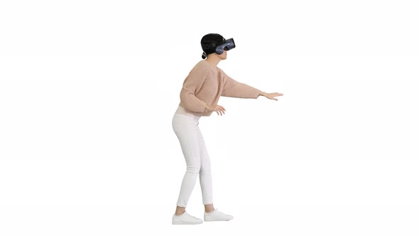 Cute Young Woman Walking and Using Interactive VR Headset on White Background.