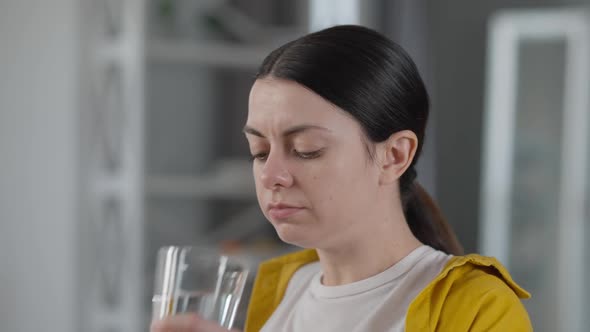 Closeup Young Woman Taking in Medications Washing Off Pills with Water