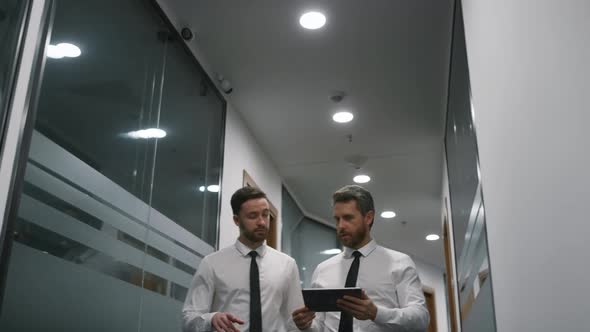 Business Team Walking Office Using Tablet Discussing Financial Plan in Office