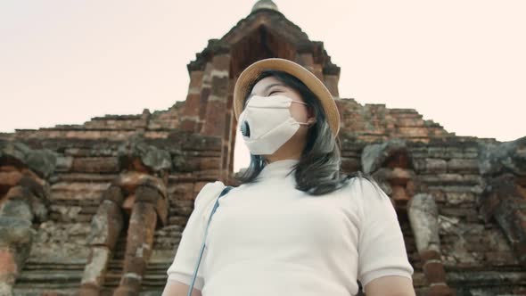 female woman wearing protective face mask walking and take photo with smartphone