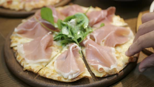 Taking a slice of pizza, Close-up Of People Hands Taking Slices Pizza on wooden tray