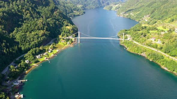 Aerial view of Fjord in Norway with a bridge crossing a lake - Flying towards the bridge