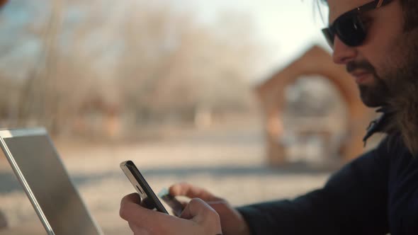 Using Mobile Phone On Nature. Holding Smartphone Using Outdoors.Businessman Chatting On Mobile Phone