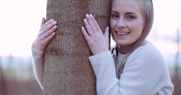 Beautiful Loving Nature Woman Hugs Tree in Forest in Autumn