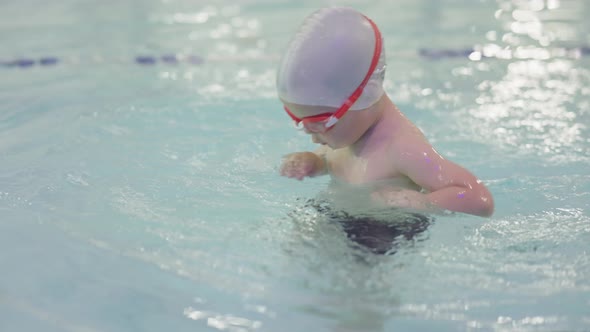 Happy 34 Year Child Kid Boy Training in Swimming Pool Wearing Goggles Cap