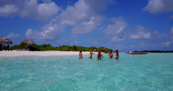 Young beauty models relaxing by the sea on the beach on clean white sand and blue background 4K