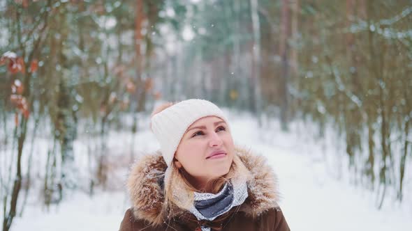 Pretty Woman in Winter Walking and Admiring the Snowy Forest