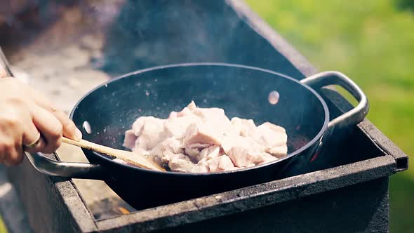 Close-up, Slow Motion: Meat Is Roasted in Cauldron, on Coals, on a Brazier, in Oil