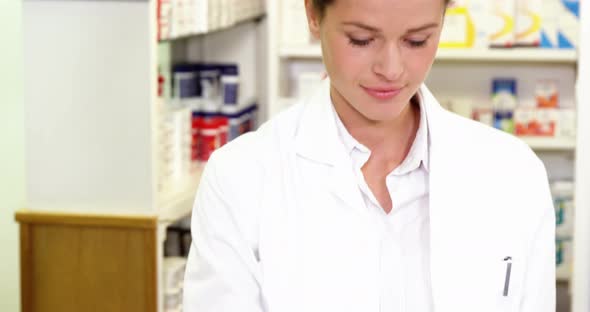 Pharmacist making prescription record in laptop