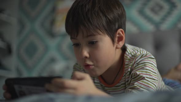 The Boy is Actively Playing Smartphone Alone in the Room